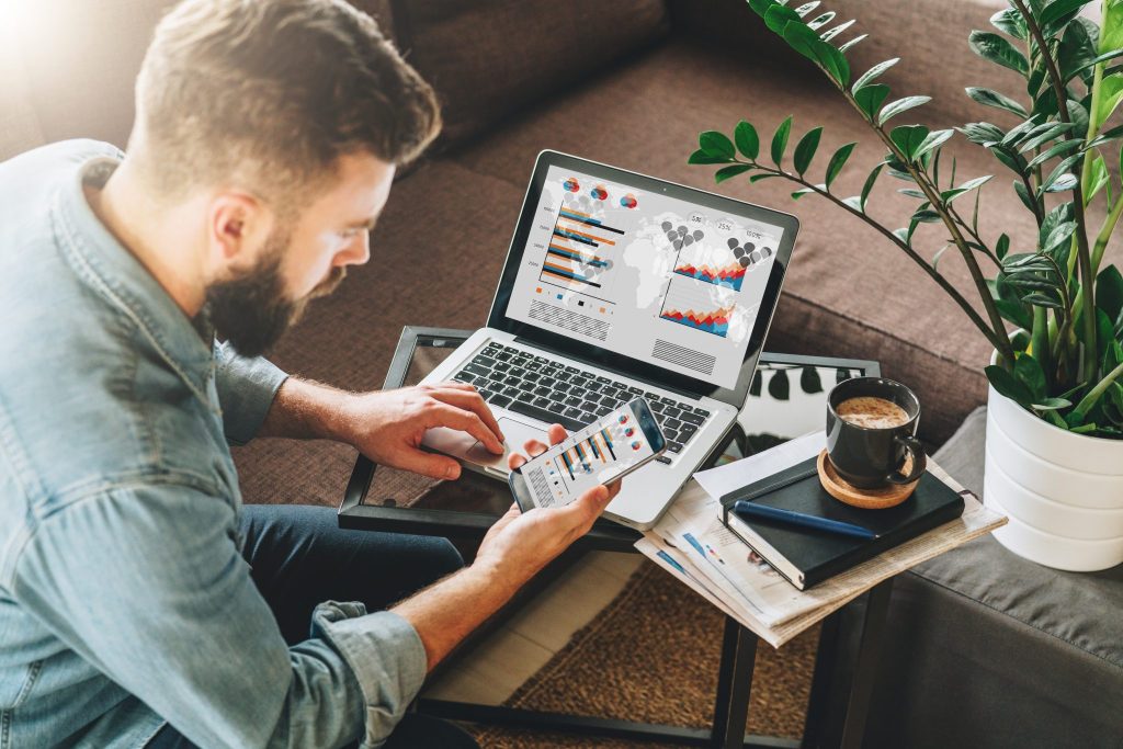 Young man working on laptop and smartphone at home